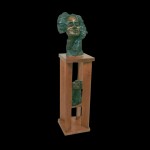 Earthy green facial sculpture on a brown stand